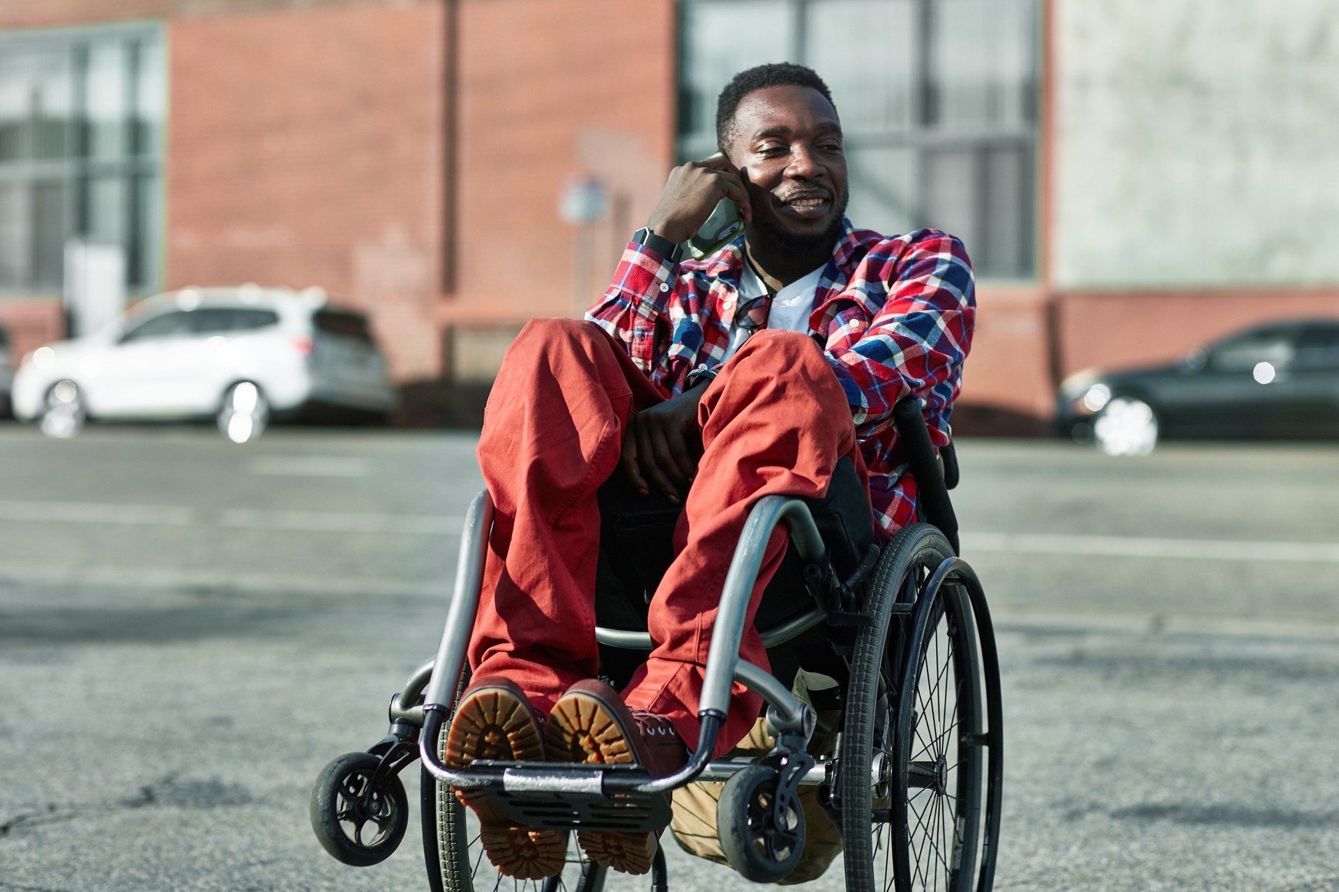Happy disabled man talking on smart phone in city